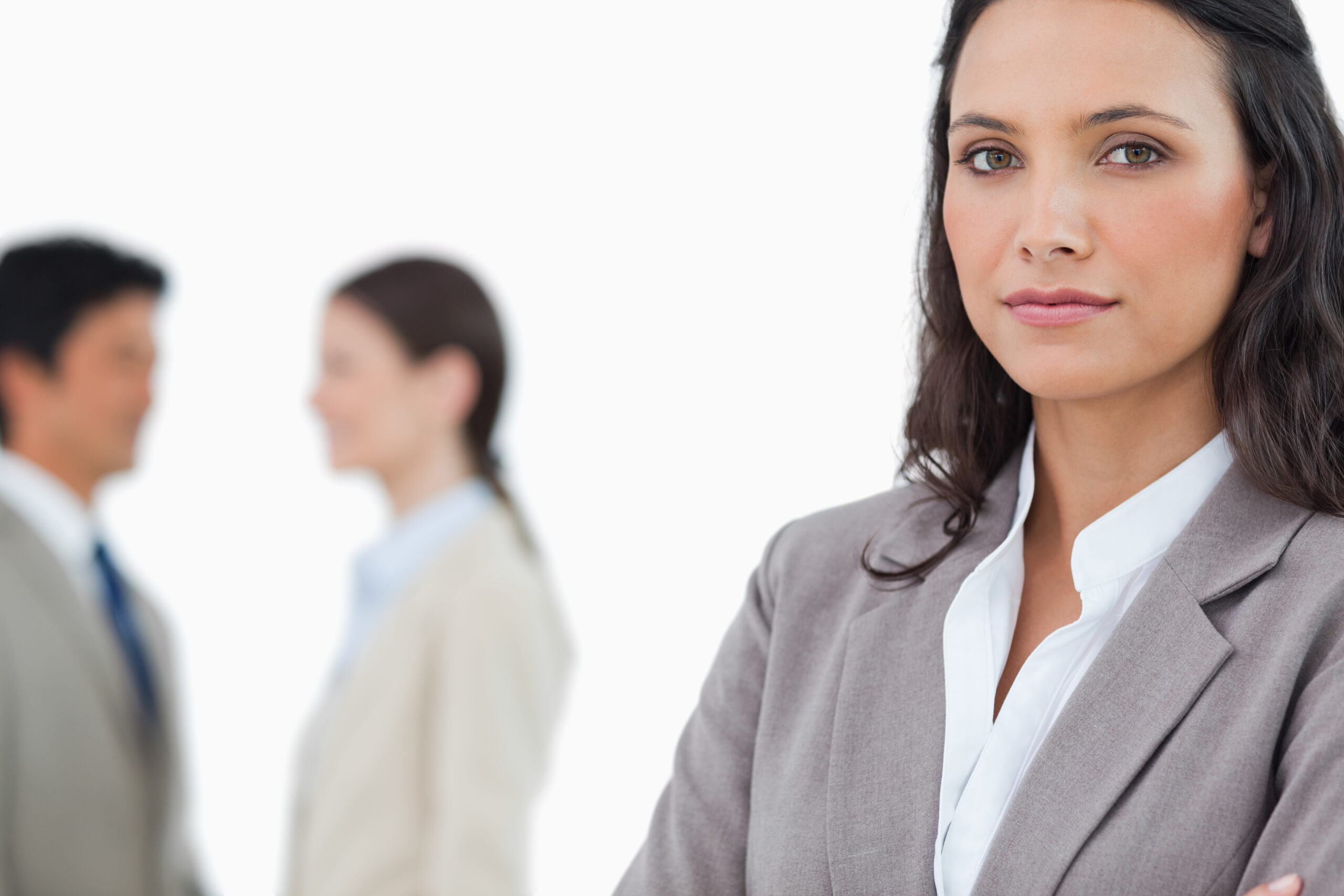 Professional woman in forefront with two professionals in the background